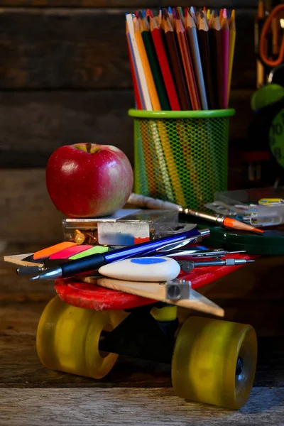 School supplies located on a skateboard.