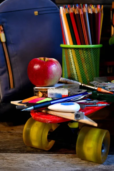 School supplies located on a skateboard.