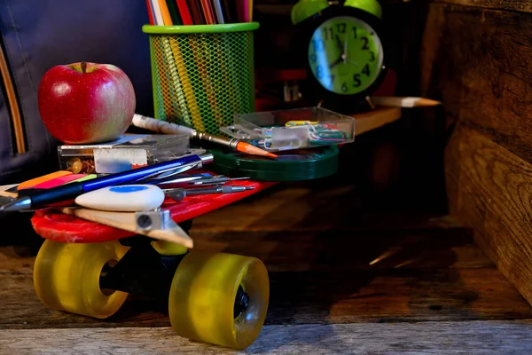 School supplies located on a skateboard.