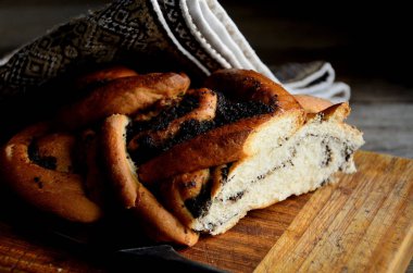 Haşhaş tohumu ile ekmek, rustik bir masada bir halk peçete bir bıçak. Tatil Makovei.