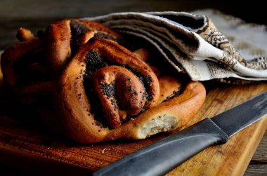 Haşhaş tohumu ile ekmek, rustik bir masada bir halk peçete bir bıçak. Tatil Makovei.