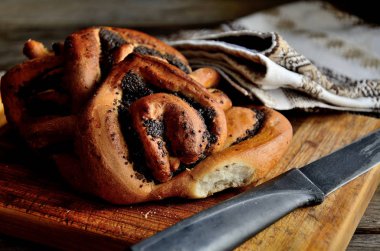 Haşhaş tohumu ile ekmek, rustik bir masada bir halk peçete bir bıçak. Tatil Makovei.