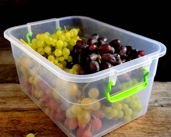 Bunches of grapes folded in a plastic food box.