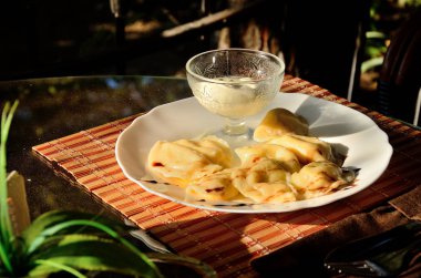 Güneşli bir günde parkta, bir yaz kafede bir masada süzme peynir ve ekşi krema ile Köfte.