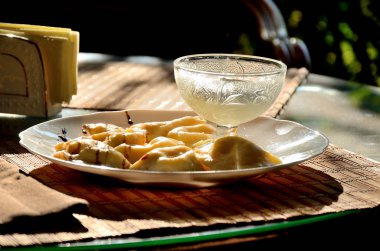 Güneşli bir günde parkta, bir yaz kafede bir masada süzme peynir ve ekşi krema ile Köfte.