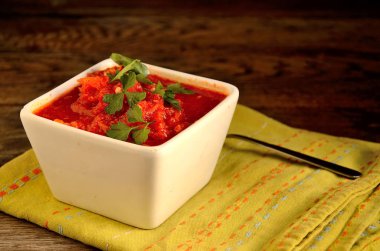 Beyaz bir kase ev adjika, folklor, eski kurulların arka planda ulusal peçete.