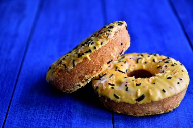 Mutfakta mavi bir arka plan üzerinde iştah açıcı donutlar.