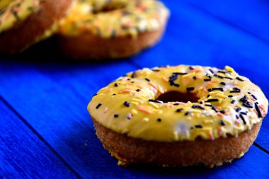 Mutfakta mavi bir arka plan üzerinde iştah açıcı donutlar.