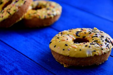Mutfakta mavi bir arka plan üzerinde iştah açıcı donutlar.