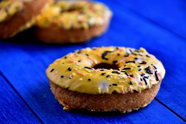 Mutfakta mavi bir arka plan üzerinde iştah açıcı donutlar.