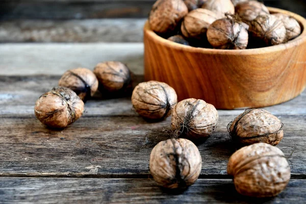Ořechy Shromážděné Dřevěné Misce Pozadí Starých Dřevěných Desek — Stock fotografie