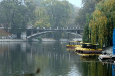 Sonbaharda eski şehir parkında gölet ve köprü..