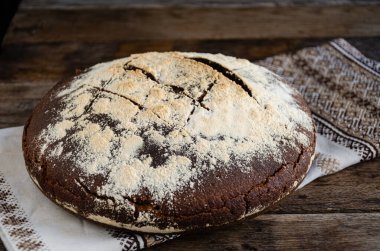 Mutfakta taze pişmiş ekmek ve ahşap bir masanın üzerinde mutfak peçetesi..