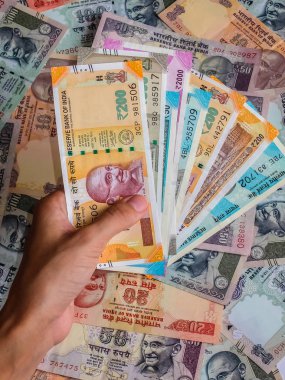 Kızılderili banknotları tutan bir kadının elleri. 10, 20, 50, 100, 200, 500 ve 2000 Hint rupisi, eski ve yeni banknotlar.