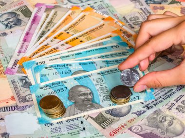 El ele tutuşarak 10, 20, 50, 100, 200, 500 ve 2000 Hint Rupisi, eski ve yeni paralar..