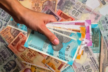 Kızılderili banknotları tutan bir kadının elleri. 10, 20, 50, 100, 200, 500 ve 2000 Hint rupisi, eski ve yeni banknotlar.