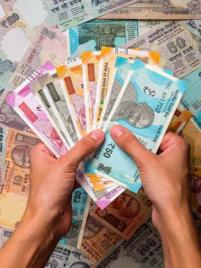 Kızılderili banknotları tutan bir kadının elleri. 10, 20, 50, 100, 200, 500 ve 2000 Hint rupisi, eski ve yeni banknotlar.