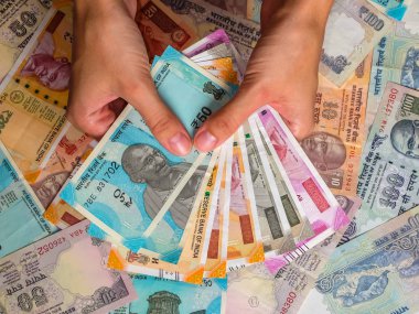 Kızılderili banknotları tutan bir kadının elleri. 10, 20, 50, 100, 200, 500 ve 2000 Hint rupisi, eski ve yeni banknotlar.