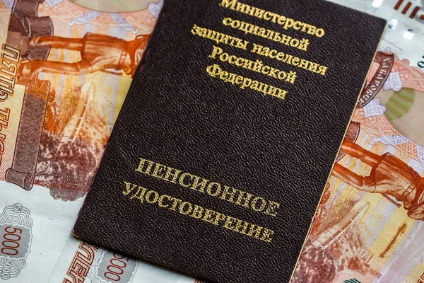 Russian pension certificate and currency (banknotes).Russian translation - Ministry of Social Protection of Population of Russian Federation. Pension Certificate.