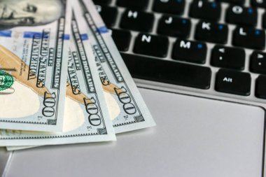 Yüz dolarlık banknotlar laptop klavye üzerinde yalan closeup görünümü.