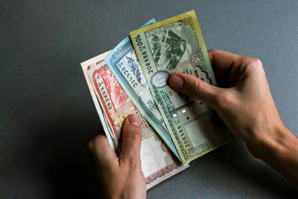 Руки с непальской валютой (банкноты)
).