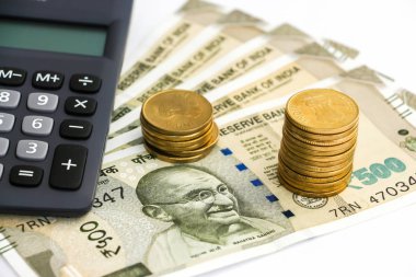 Hesap makinesi, yeni Hint 500 rupi banknot ve madeni paralar bakış beyaz arka plan üzerinde kapatın.