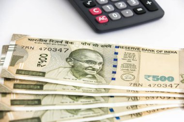 Hesap makinesi ve yeni Hint 500 rupi banknotlar bakış beyaz arka plan üzerinde kapatın.