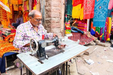 Jodhpur, Hindistan - Mart, 2018 yaklaşık. Adam dikiş makinesi onun atölye yerel pazarda Jodhpur elbise dikmek.