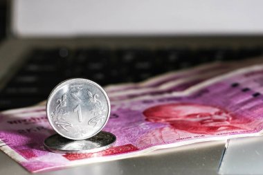 Yepyeni Hint 2000 rupi banknotlar ve laptop üzerinden bir Rupisi sikke yakın yukarı görünümü.