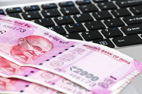 Yepyeni Hint banknotlarının ve dizüstü bilgisayarların yakın görüntüsü.