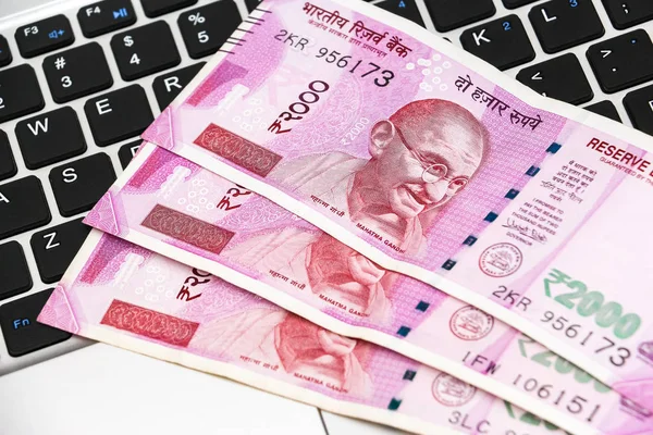 Yepyeni Hint banknotlarının ve dizüstü bilgisayarların yakın görüntüsü.