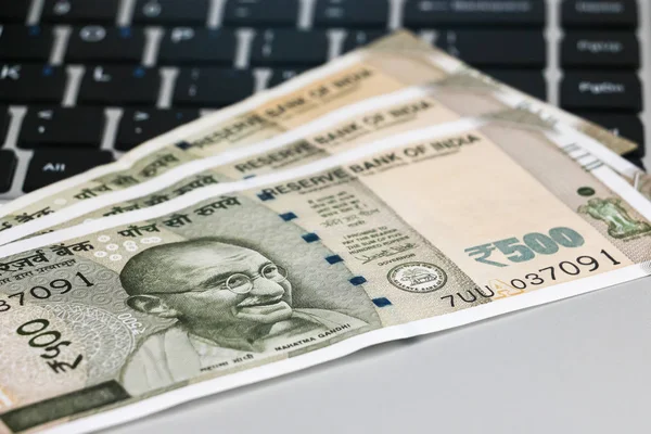 Yepyeni Hint 500 rupi banknotlar ve laptop yakın görünüm.