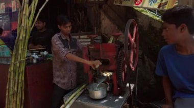 Rishikesh, Hindistan - Eylül 2019. Adam Rishikesh sokaklarında taze şeker kamışı suyu yapıyor..