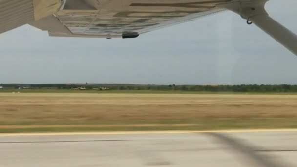 ランディング フレームで翼と小型飛行機の窓からコンクリートの滑走路 を表示 — ストック動画