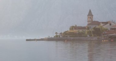 Kotor körfezinin bir bölümünde sakin sabah - su ve taş kilise ile panorama