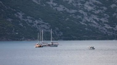 Arka planda deniz kenarı ile Kotor Körfezi'nde çeşitli teknelerin zaman atlamalı