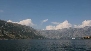 Güneşli bir günde bir koyda tepenin üzerinde güzel bulutların zaman atlamalı gemiler tarafından geçen