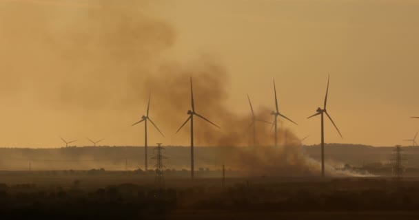 Farm Wind Turbines Smoke Burning Field Twilight Telephoto Lens — Stock Video