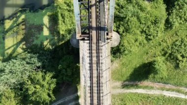 Eski bir demiryolu köprüsünün üzerinde kameralı bir drone ile karanlık bir nehre ayarlanmış bir uçuş.