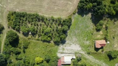 Gökyüzünde bir İHA ile dağlarda bir orman kenarında bir yazlık evin üzerinde uçmak