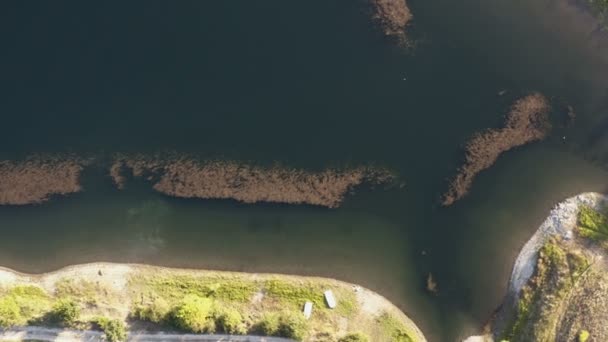 Vol avec un drone au-dessus d'un immense lac de montagne trouble par sa côte rocheuse au milieu des montagnes
