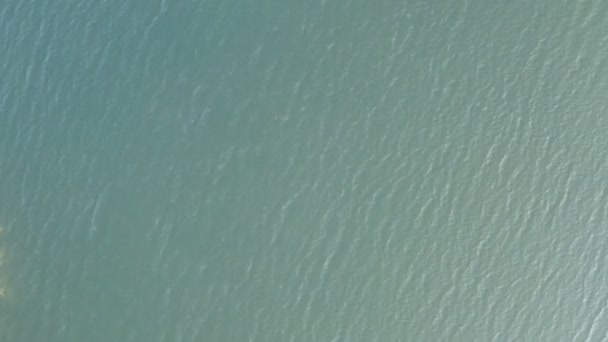 Vol avec un drone au-dessus d'un lac de montagne avec une forêt épaisse et une côte rocheuse qui l'entoure