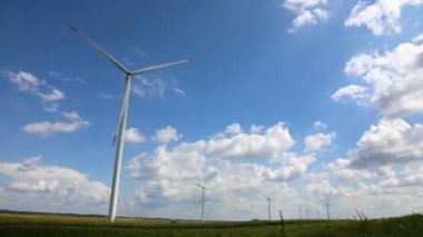 Rüzgâr jeneratörü tarla zaman aşımına uğradı hareket eden beyaz kabarık bulutlar ve mavi gökyüzü