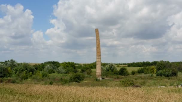 多云的一天 与一架无人驾驶飞机在乡间田野中央的一个旧砖炉旁近距离飞行 — 图库视频影像
