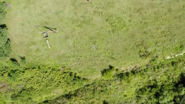 Parlak güneşli bir günde, küçük bir köyde kuyu kazarak büyük bir evin ve bahçesinin üzerinde İHA ile uçmak.