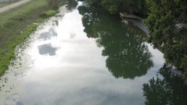 Güzel bulutlu bir günde şelalenin yanında küçük bir nehre yakın uçuyor.
