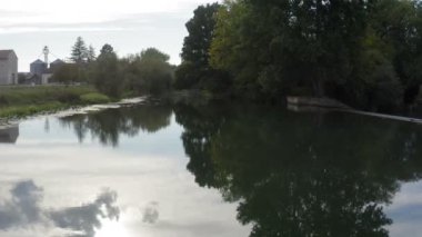 Güzel ama kasvetli ve bulutlu bir günde kırsal bir nehrin üzerinde bir dronla alçak uçuş.