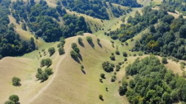Güneşli bir günde güzel ve manzaralı bir tepenin üzerinde bir dronla uçmak.
