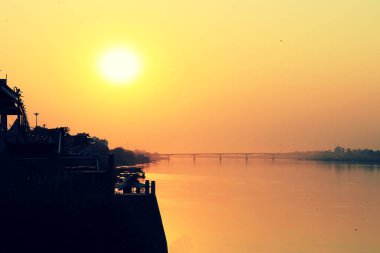 Gün batımı gözcü noktası üzerinde renkli gün batımı, köprü ve nehirde turuncu yansıması ile Mekong