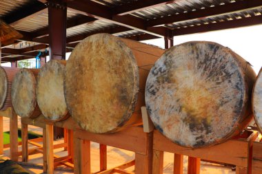 Kültür parkında sergilenen ahşap masalara yatan Budist davullar 